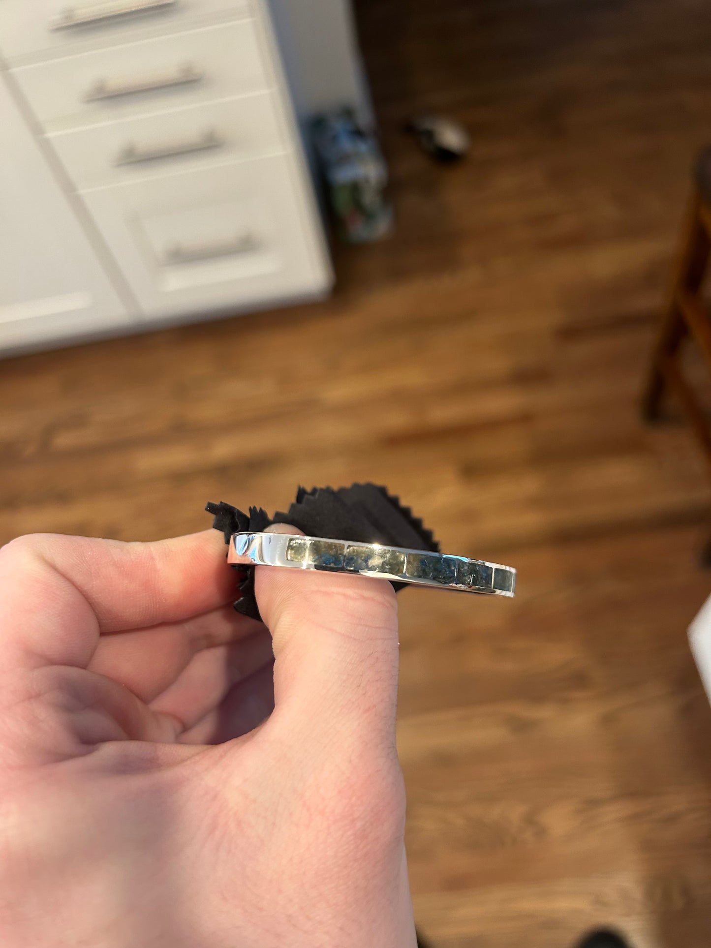Hand holding a silver bracelet with a blurred background
